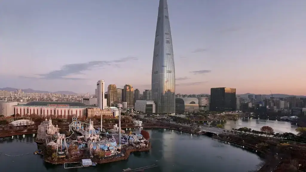 Lago Seokchon ao entardecer com o castelo do Lotte World e a Lotte Tower