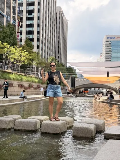 Viajante sobre as pedras de travessia do riacho Cheonggyecheon