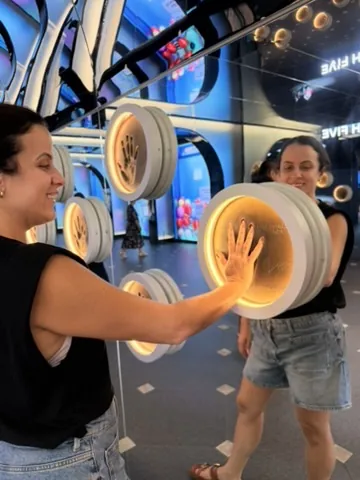 Duas amigas brincando com uma instalação interativa de luz