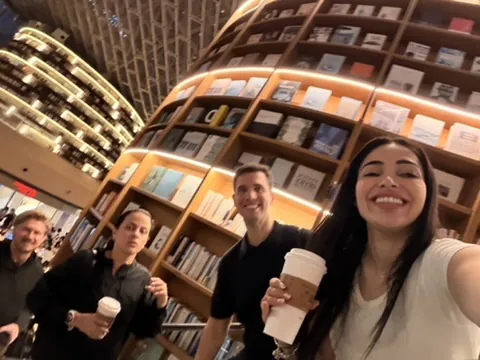Grupo numa selfie com cafés na mão entre as estantes da Starfield Library